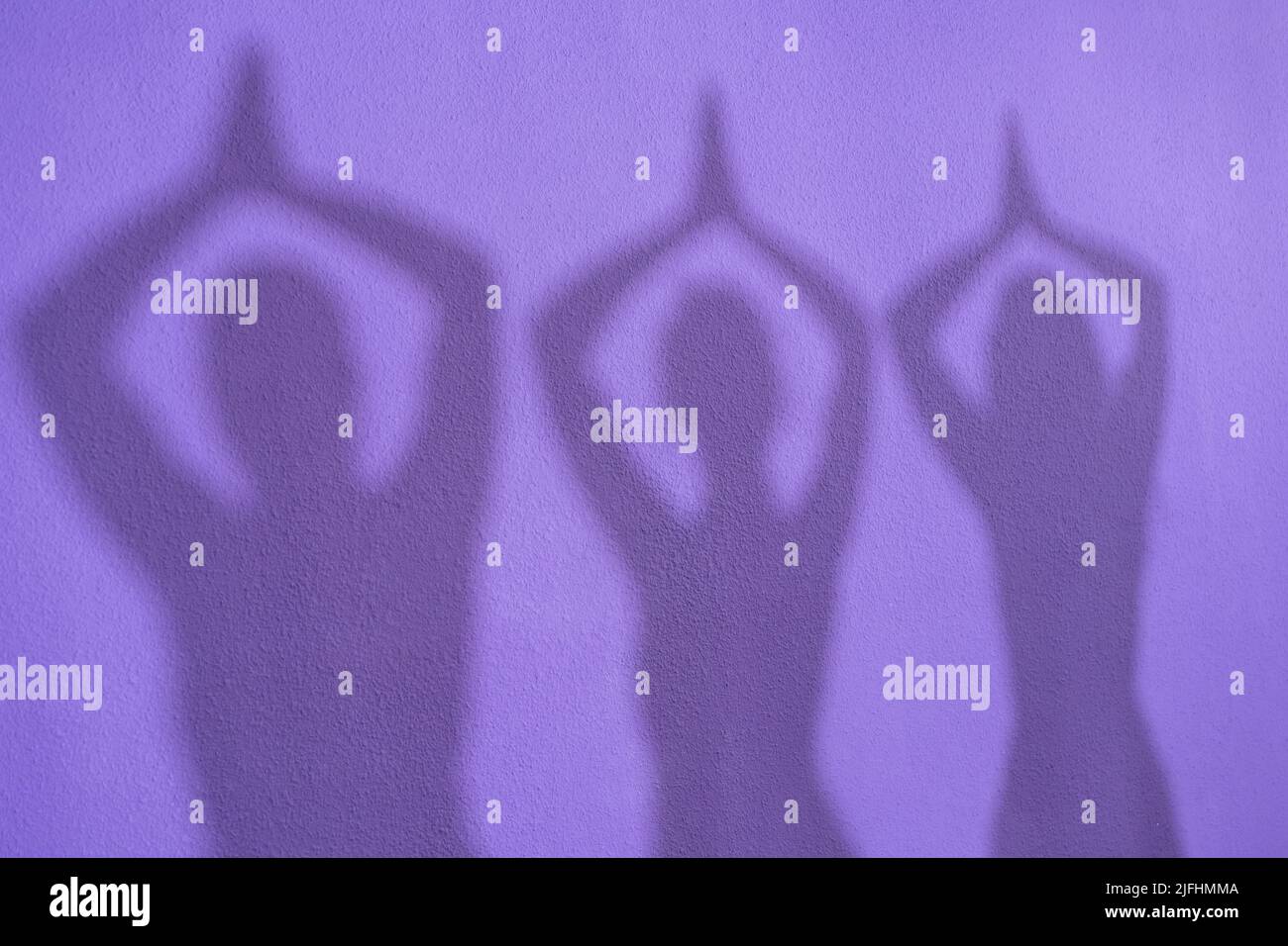 Shadows of a group of women practicing the tree posture, Vriksasana, on yoga class Stock Photo