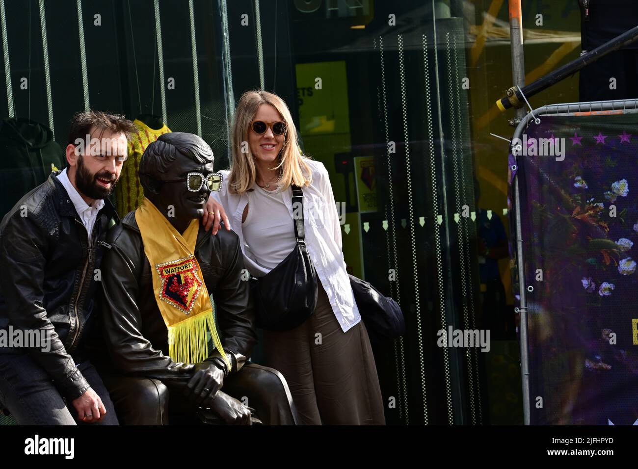 Fans pose with Graham Taylor Statue with Watford FC scarf Stock Photo
