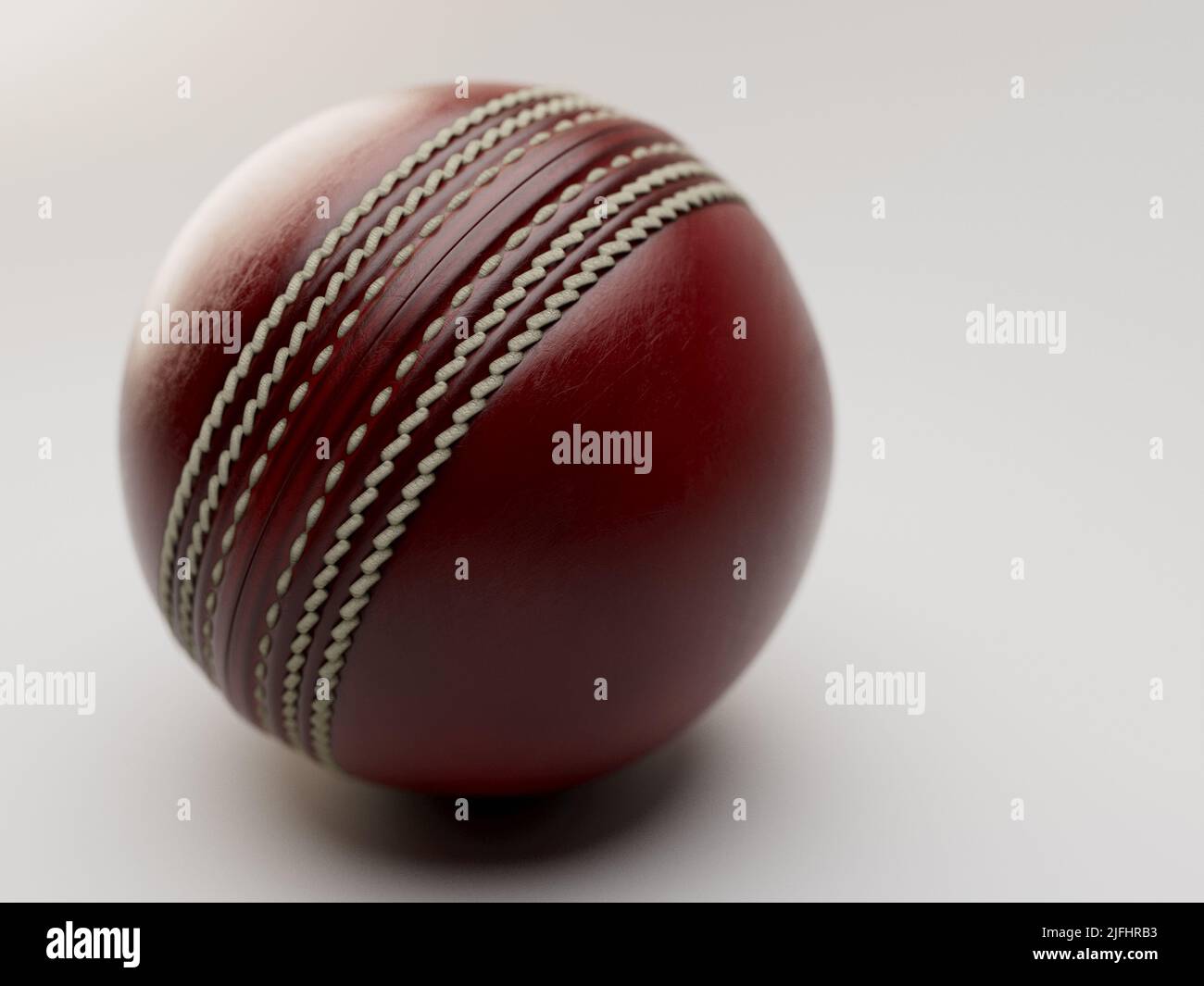 A regular red cricket ball with white stitching on an isolated