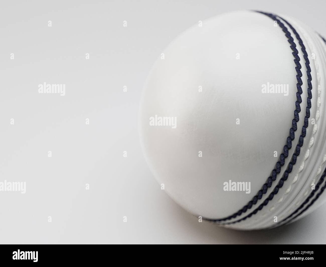 A regular white cricket ball with navy stitching on an isolated