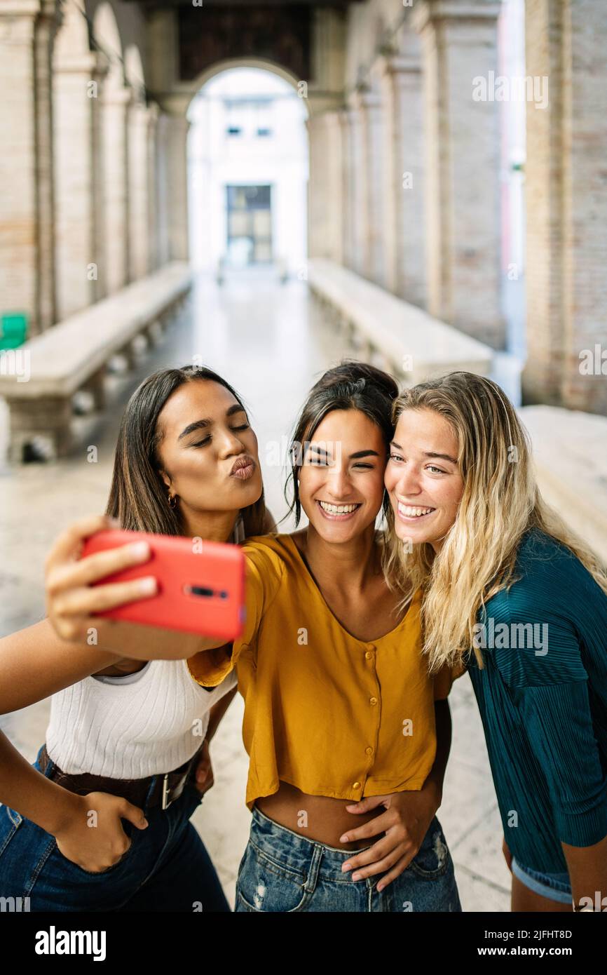 Group of multiracial young women taking selfie photo on cellphone outdoor Stock Photo
