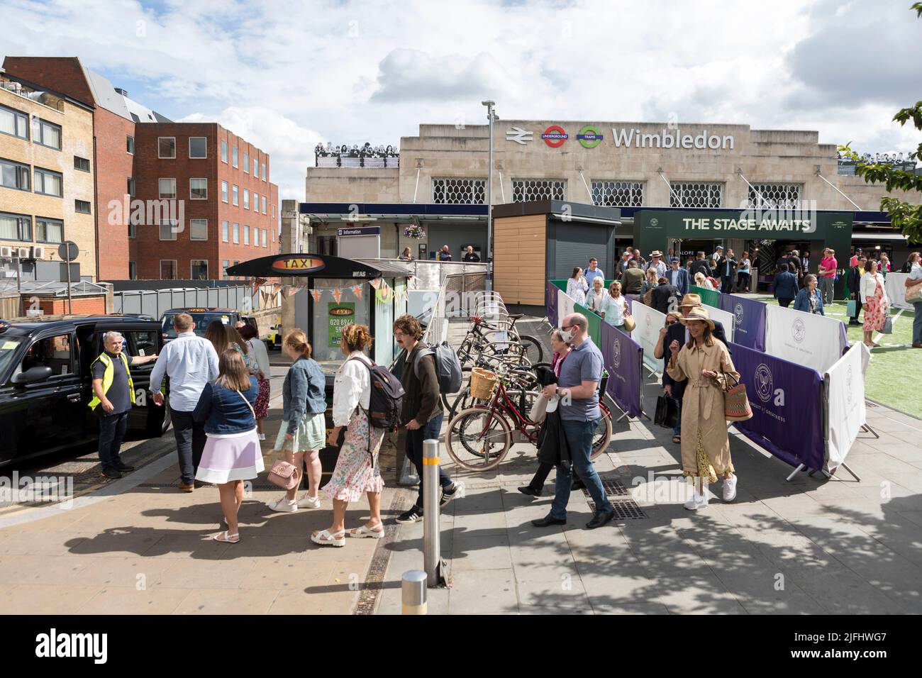 Tennis fans ushered into shared taxis outside Wimbledon train station ahead of the 2022 Championship.   Image shot on 27th June 2022.  © Belinda Jiao Stock Photo