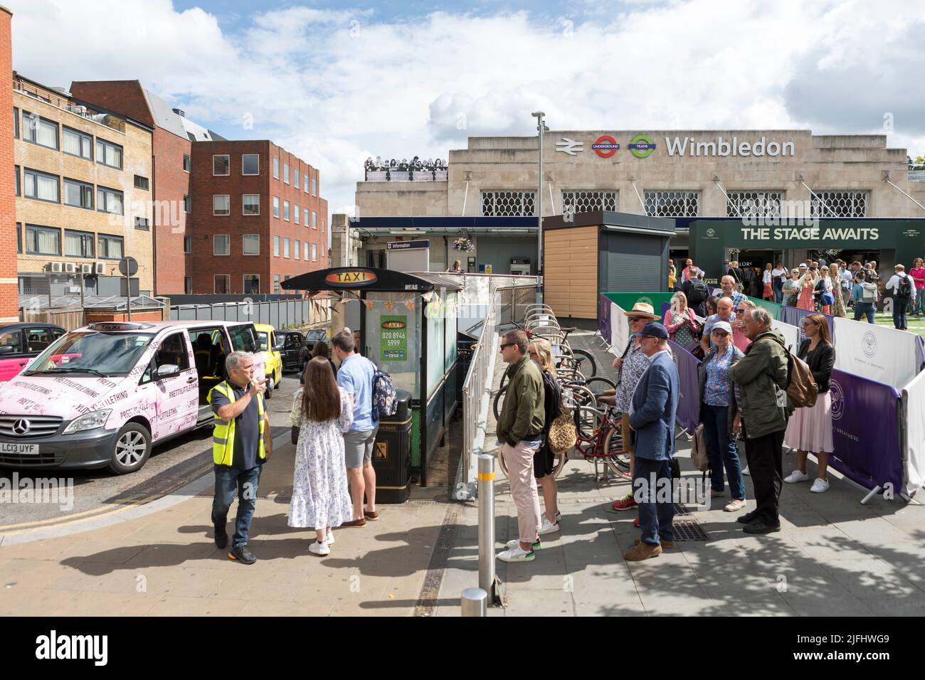 Tennis fans ushered into shared taxis outside Wimbledon train station ahead of the 2022 Championship.   Image shot on 27th June 2022.  © Belinda Jiao Stock Photo