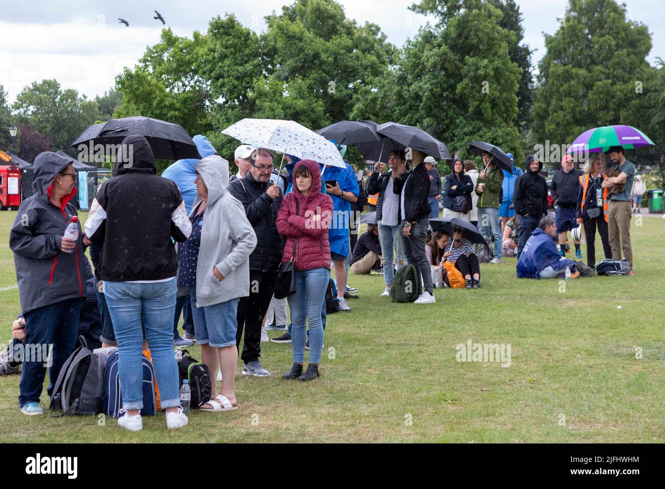 Tennis fans brace rain while queuing at Wimbledon Park ahead of the 2022 Championship.   Image shot on 27th June 2022.  © Belinda Jiao   jiao.bilin@gm Stock Photo