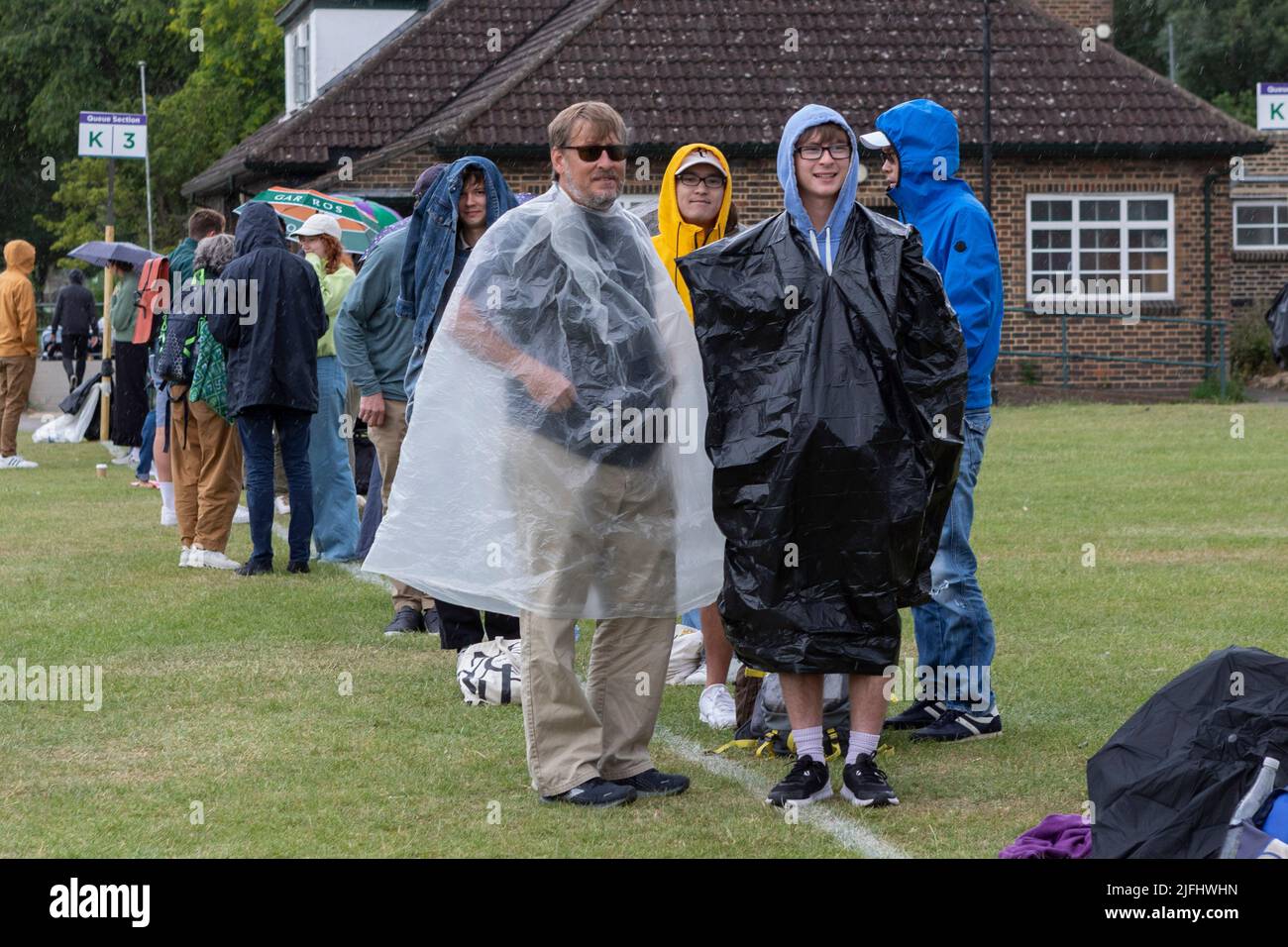 Tennis fans brace rain while queuing at Wimbledon Park ahead of the 2022 Championship.   Image shot on 27th June 2022.  © Belinda Jiao   jiao.bilin@gm Stock Photo