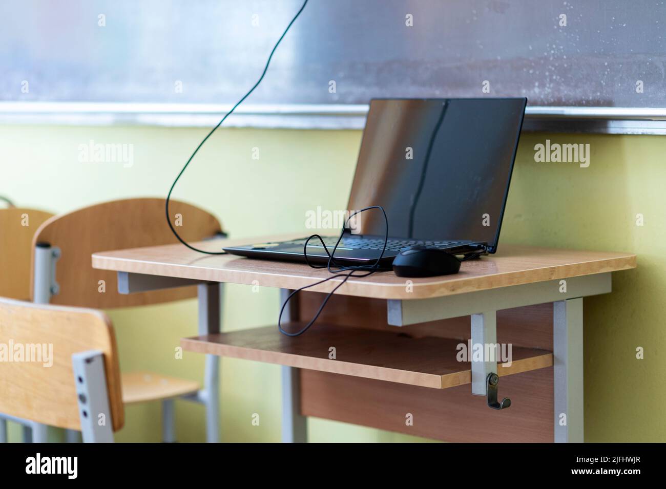Computer on wooden table in classroom Stock Photo