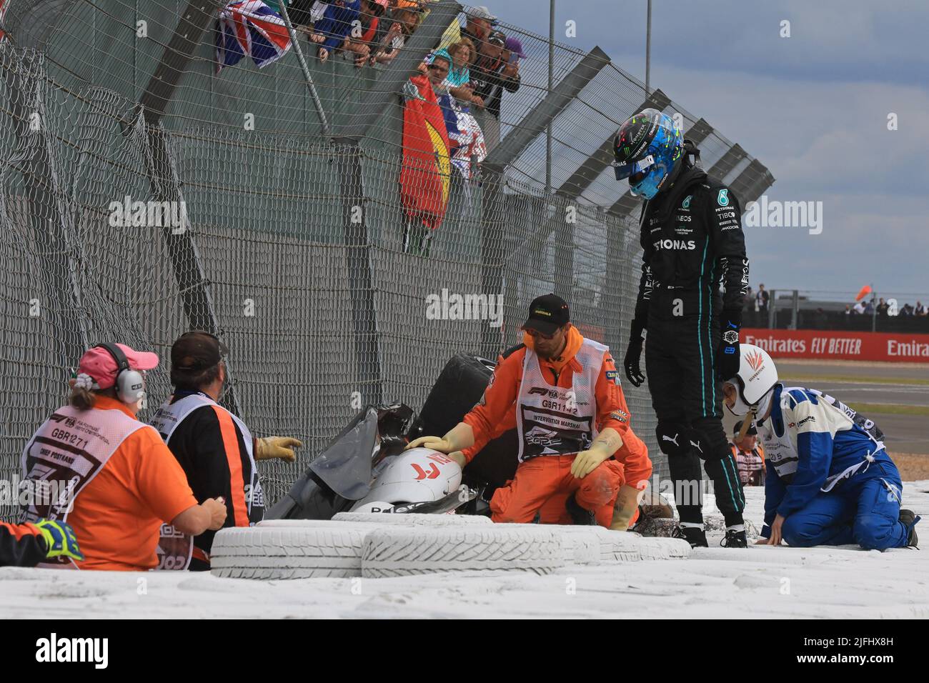 Silverstone, UK. 3rd July 2022, Silverstone Circuit, Silverstone, Northamptonshire, England: British F1 Grand Prix, Race day: Mercedes AMG Petronas F1 Team, George Russell waits at Alfa Romeo F1 Team Orlen, Guanyu Zhou to make sure he is ok Credit: Action Plus Sports Images/Alamy Live News Stock Photo