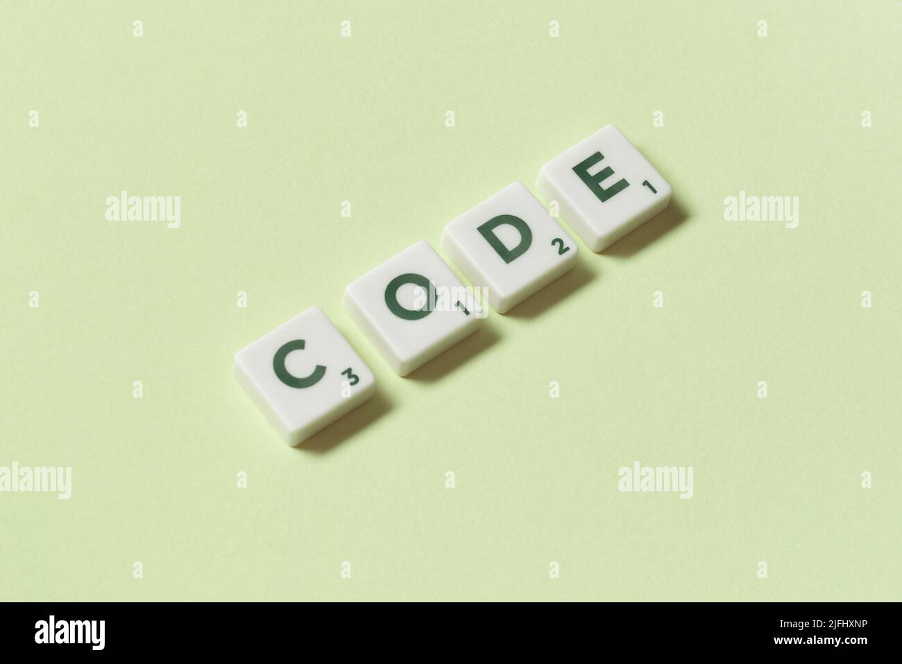 Code formed of scrabble elements on green background. Stock Photo