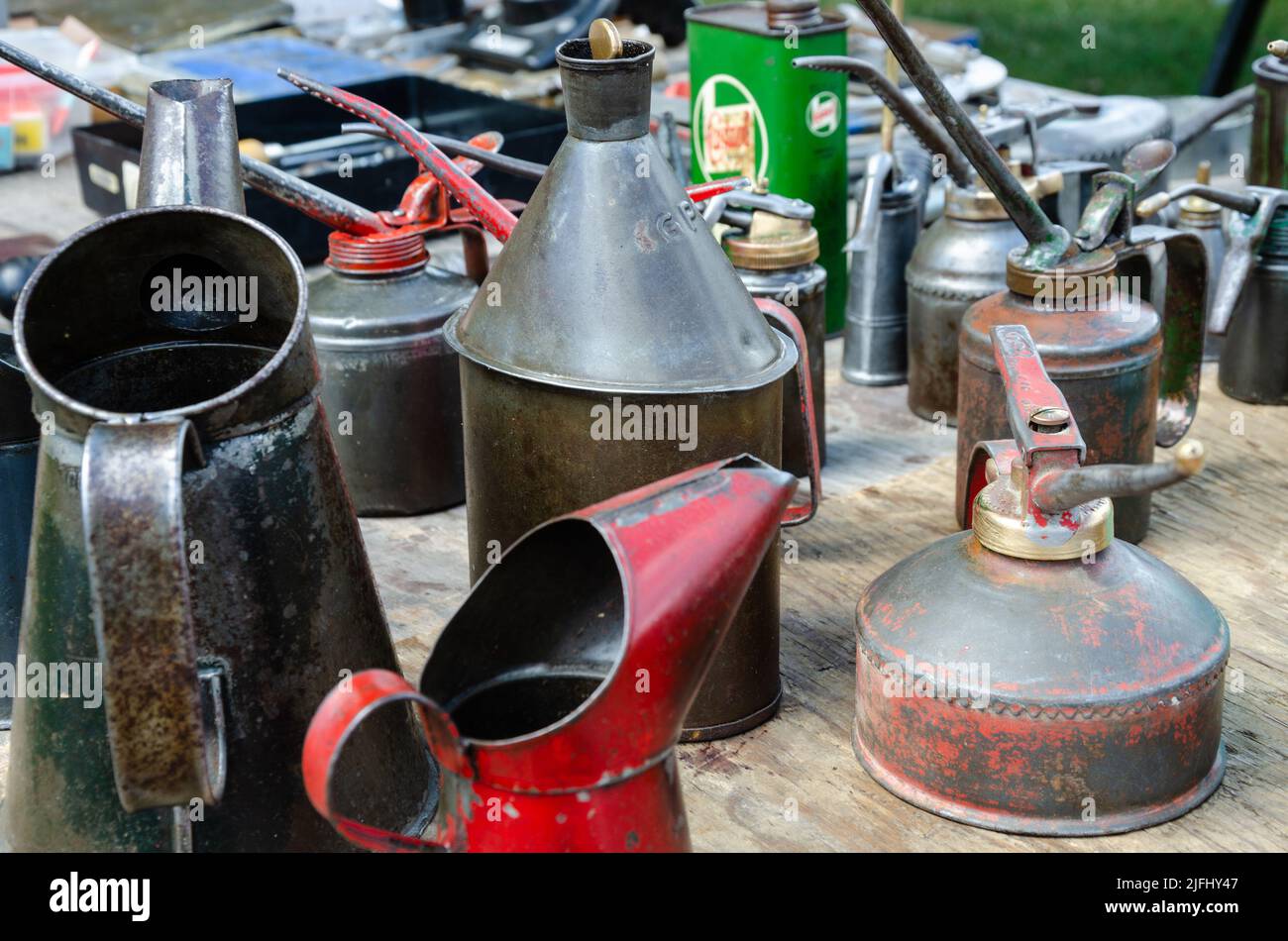 A collection of old, metal oil cans used to apply lubrication to a car
