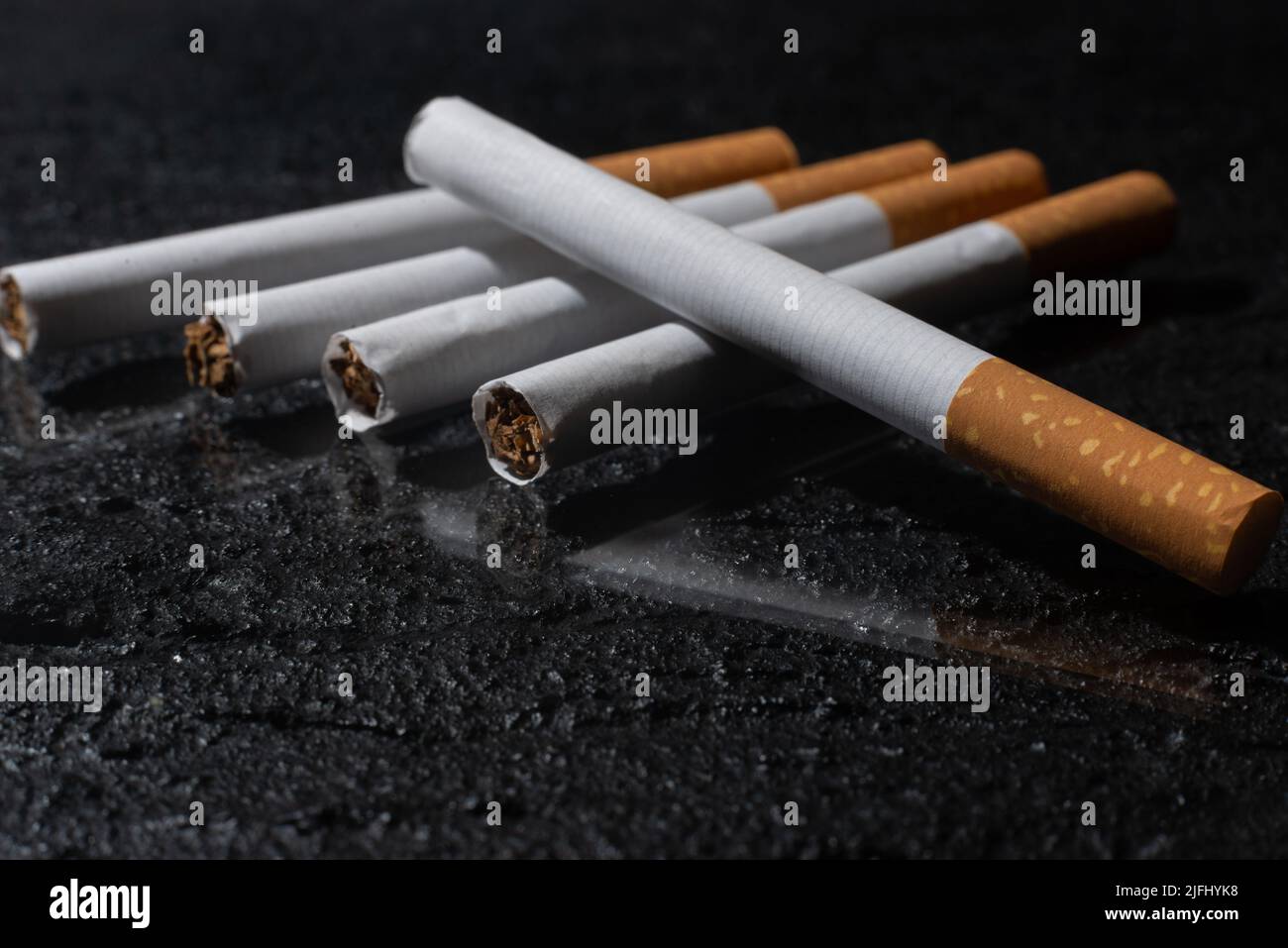 Cigarette and smoking tobacco leaves on a dark background. Unhealthy