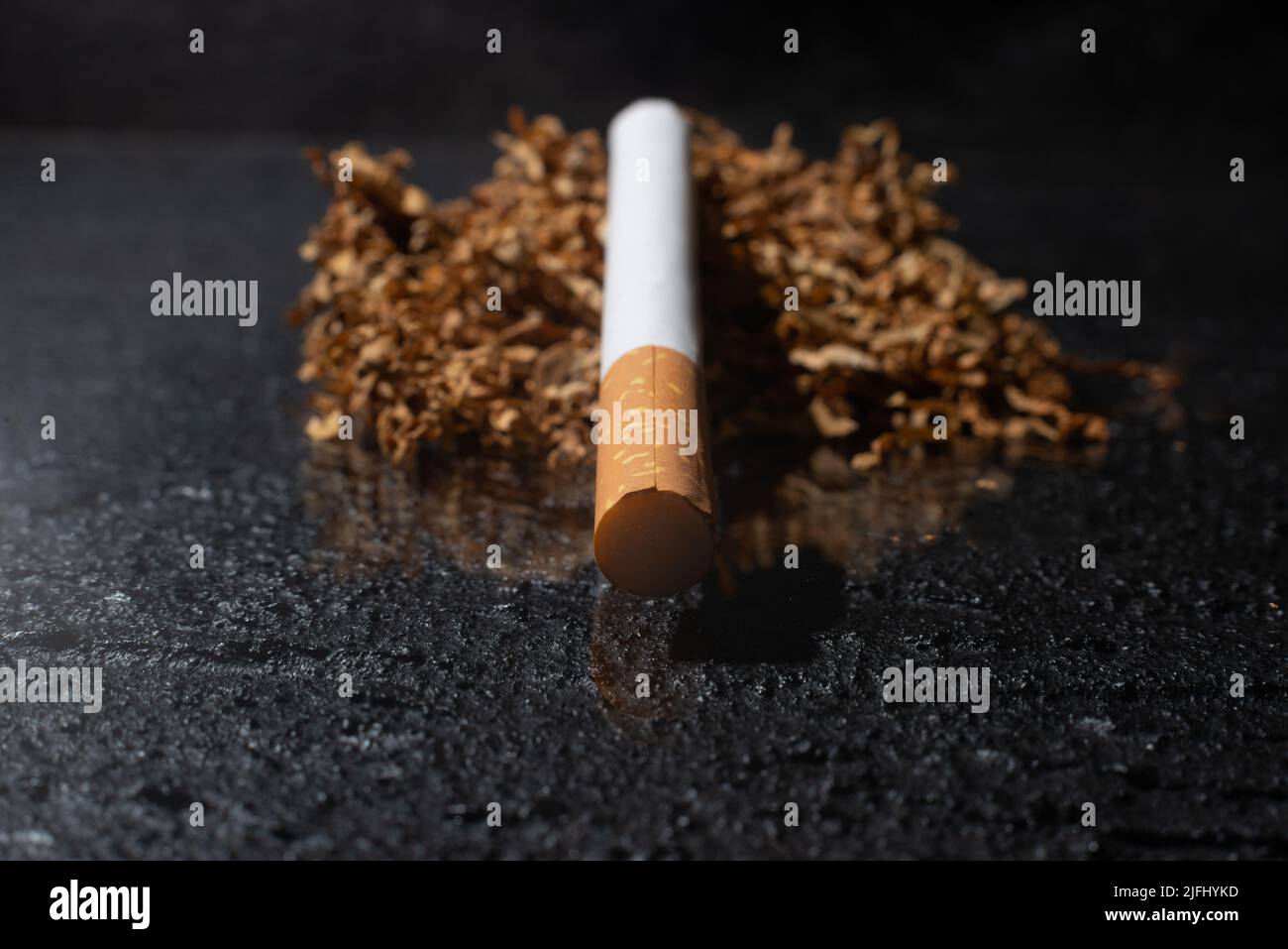 Cigarette and smoking tobacco leaves on a dark background. Unhealthy