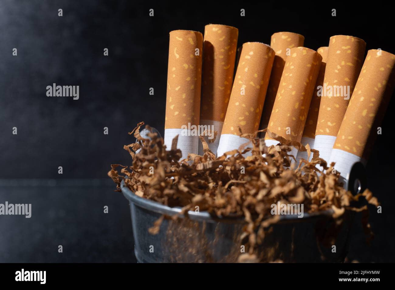 Cigarette and smoking tobacco leaves on a dark background. Unhealthy