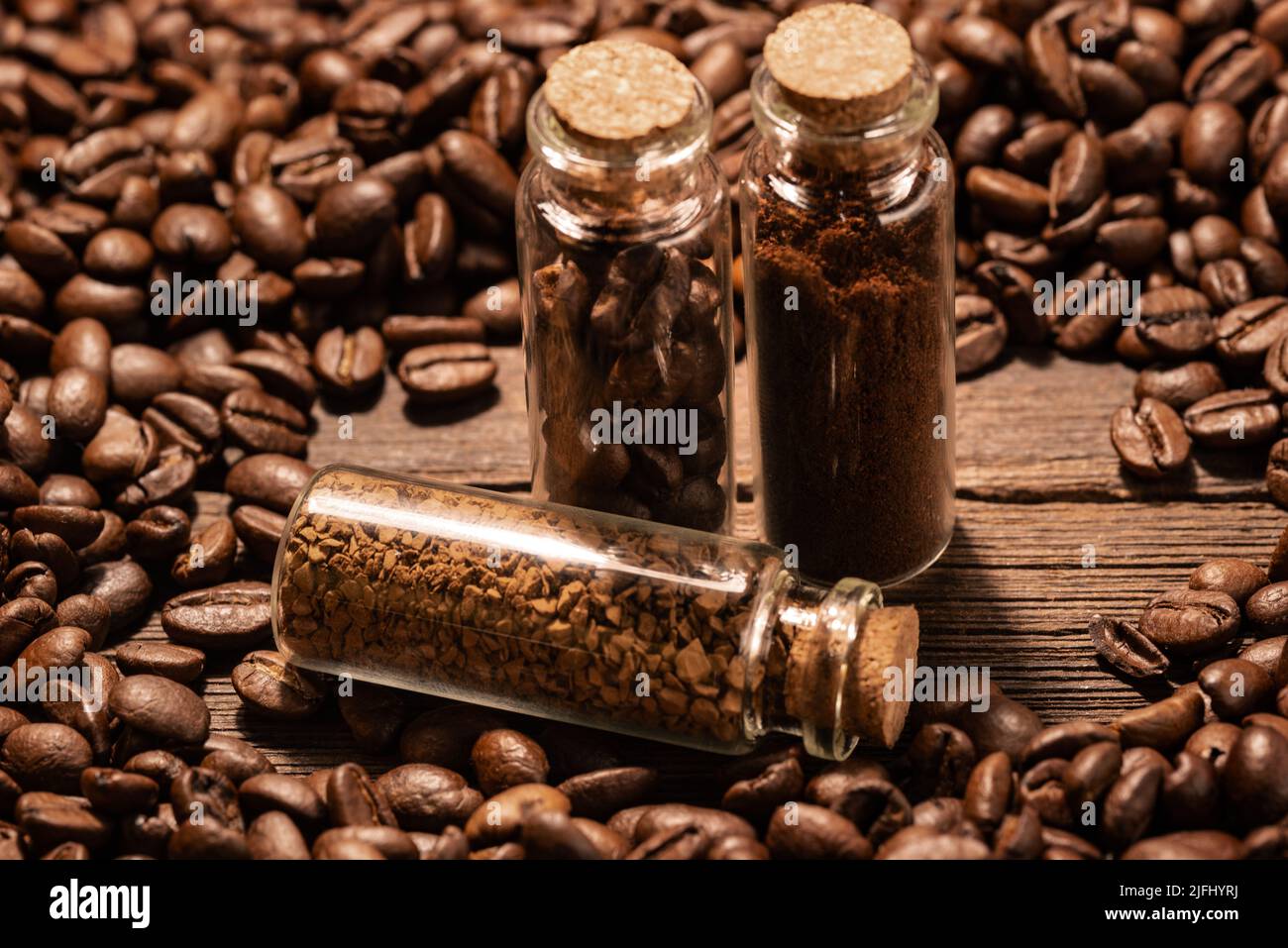 Ground coffee and instant coffee in flasks on a background of roasted