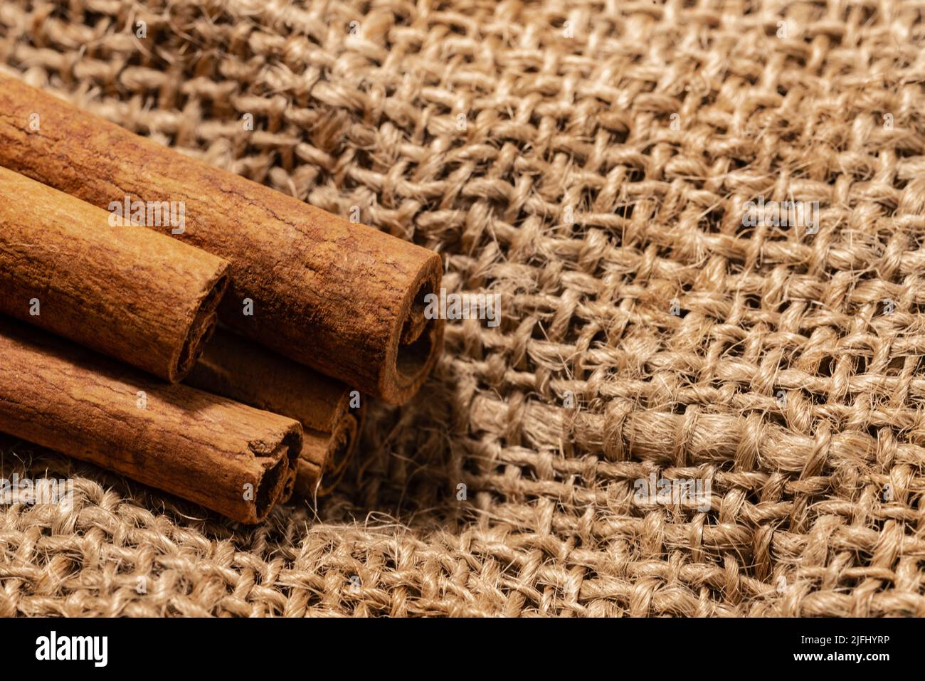 Close-up of cinnamon sticks on burlap background Stock Photo