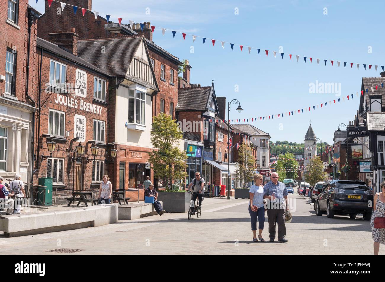 Older couple walking in Derby Street, Leek town centre, Staffordshire, England, UK Stock Photo