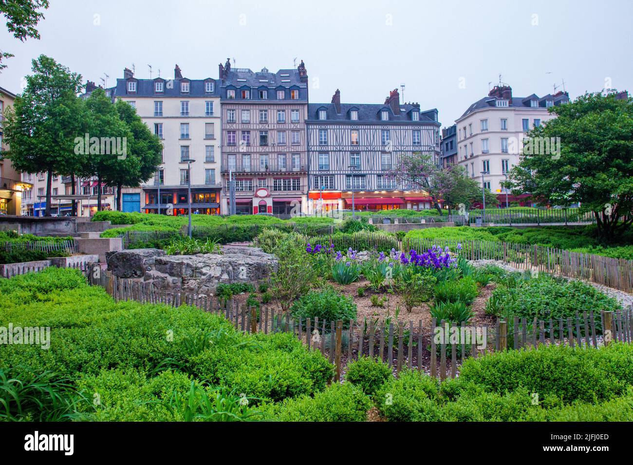05-12-2015 Rouen, France. Garden with blue irisesnext to  Church of St. Joan of Arc  and lights of cafe in downtown of  Capital of Normandy Stock Photo