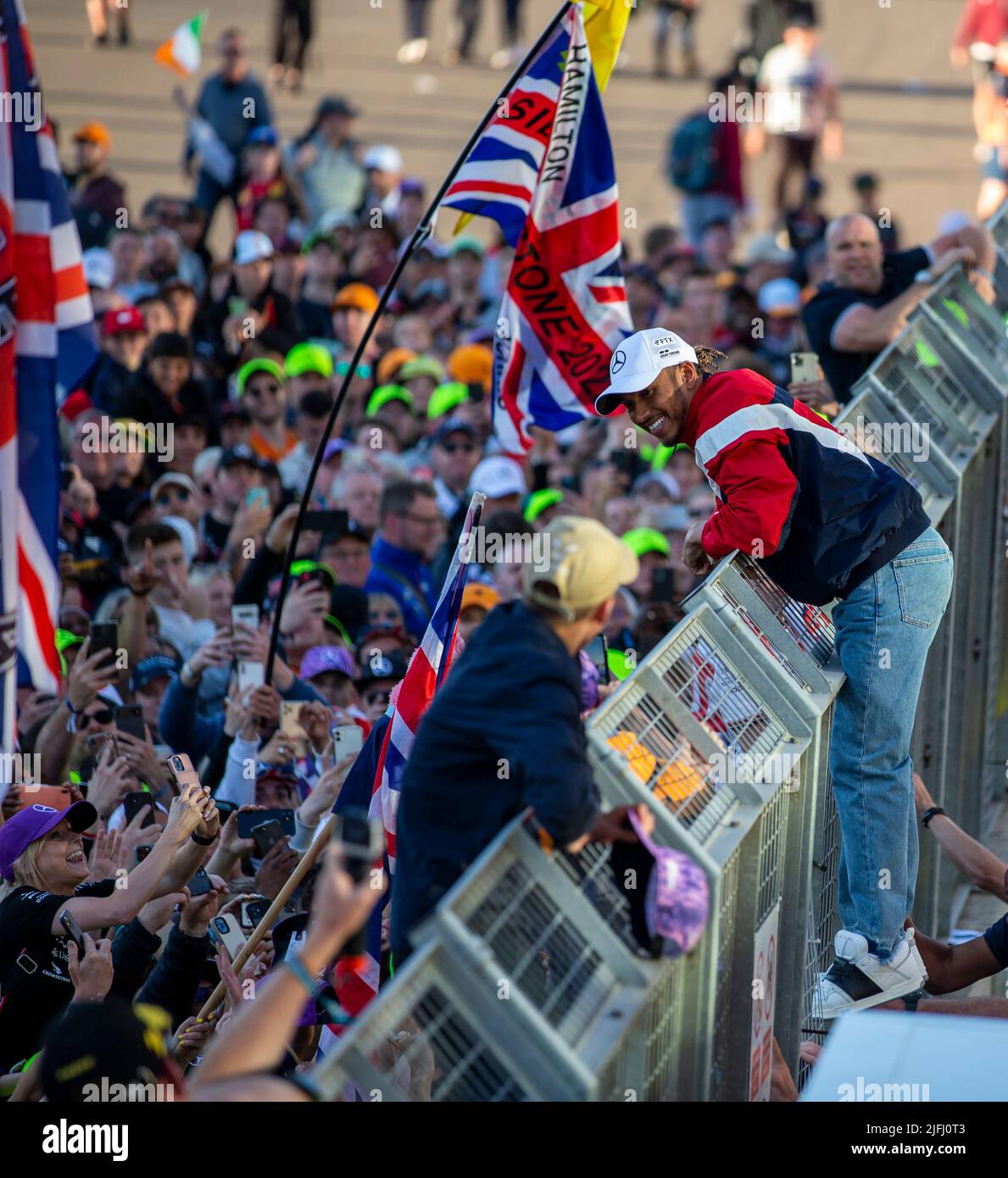 Silverstone, UK. 3rd July 2022, Silverstone Circuit, Silverstone, Northamptonshire, England: British F1 Grand Prix, Race day: Mercedes-AMG Petronas F1 Team driver Lewis Hamilton climbs the fence to meet his fans Credit: Action Plus Sports Images/Alamy Live News Stock Photo