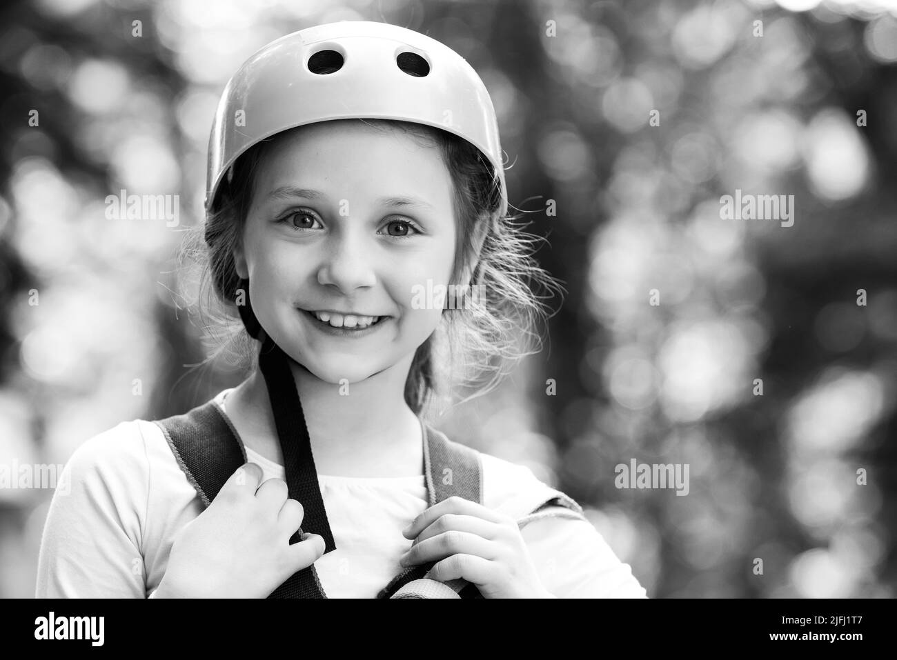 Roping park. Happy little girl climbing in the trees. Teenager girl adventure and travel. Beautiful Little girl climbing and having fun in adventure P Stock Photo