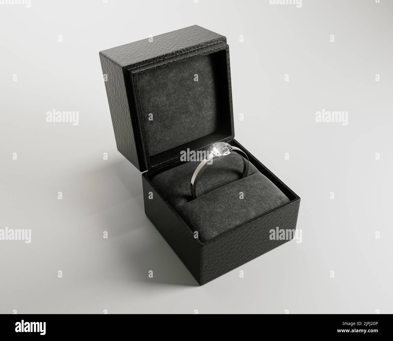 An open cube shaped black ring box with a silver engagement ring and
