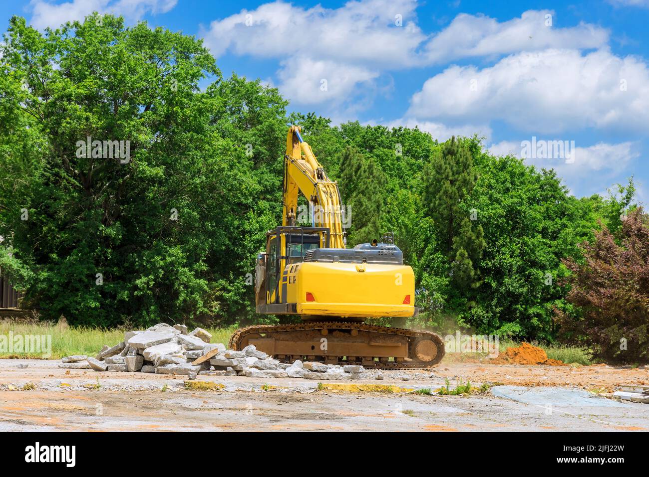 Excavator on a construction site cuts and crumbles old concrete crusher