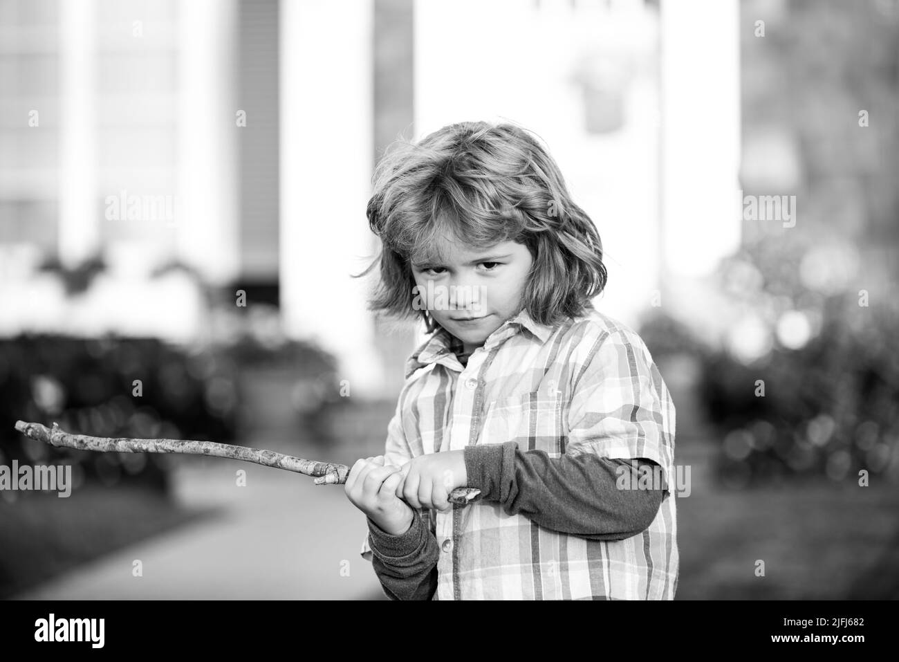 Child aggression. Negative kids emotion. Angry boy with stick. Kid