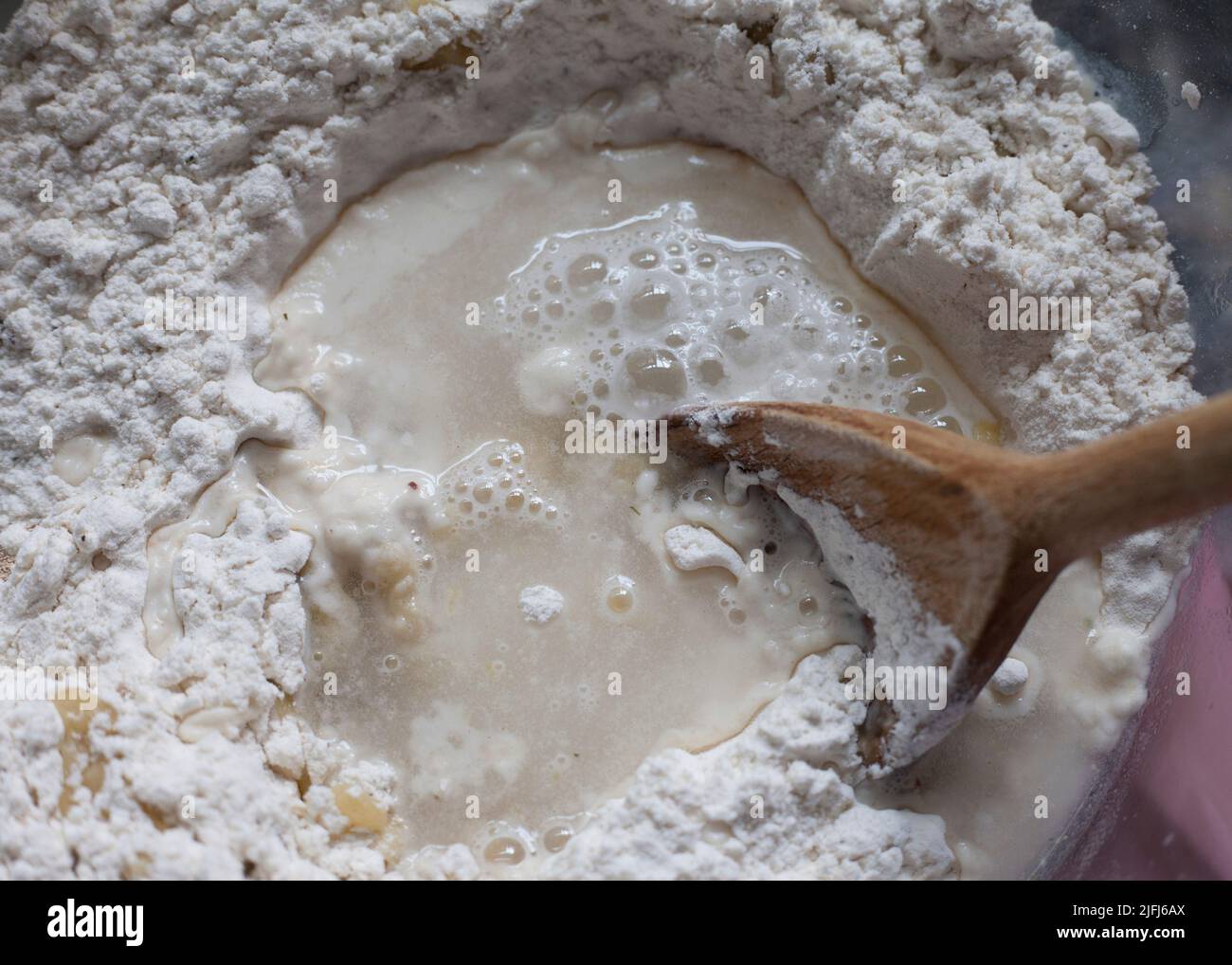 Mixing the water and oil into flour to make bread Stock Photo