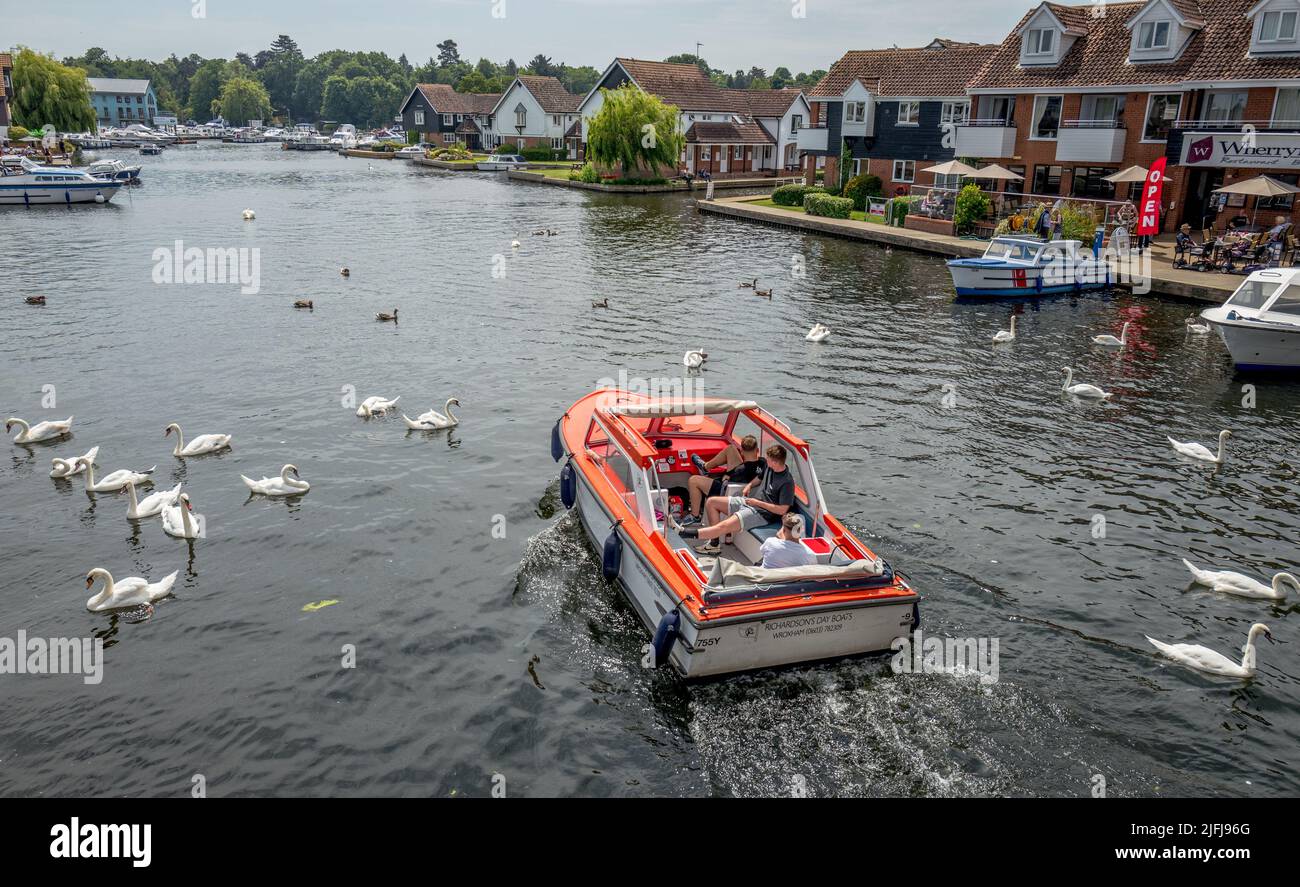 Group of young men or lads enjoying taking a hire river cruise boat on