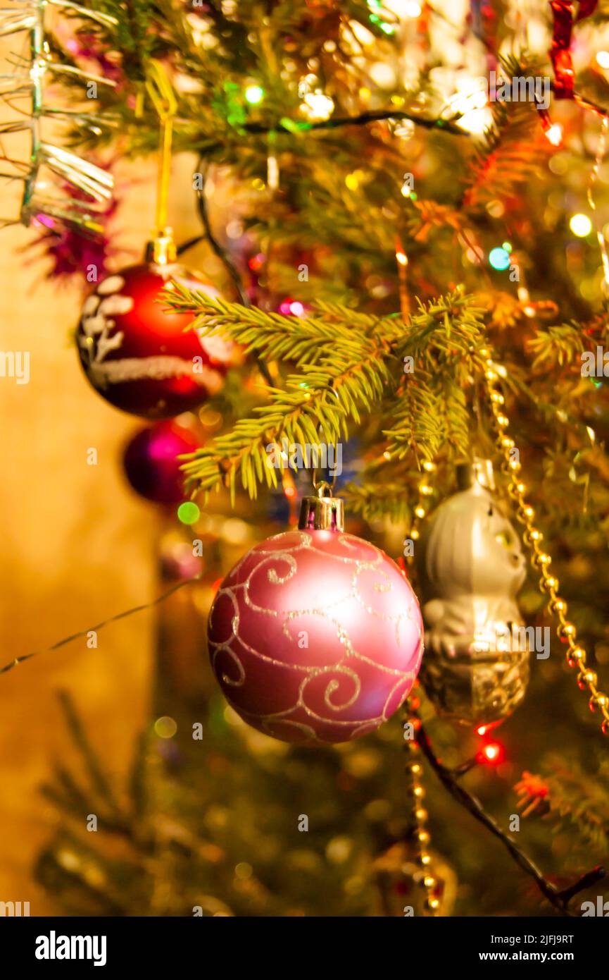 The holiday is a new year or Christmas, in the photo a live fir tree is decorated with toys, tinsel and beads. Retro. - Stock Image