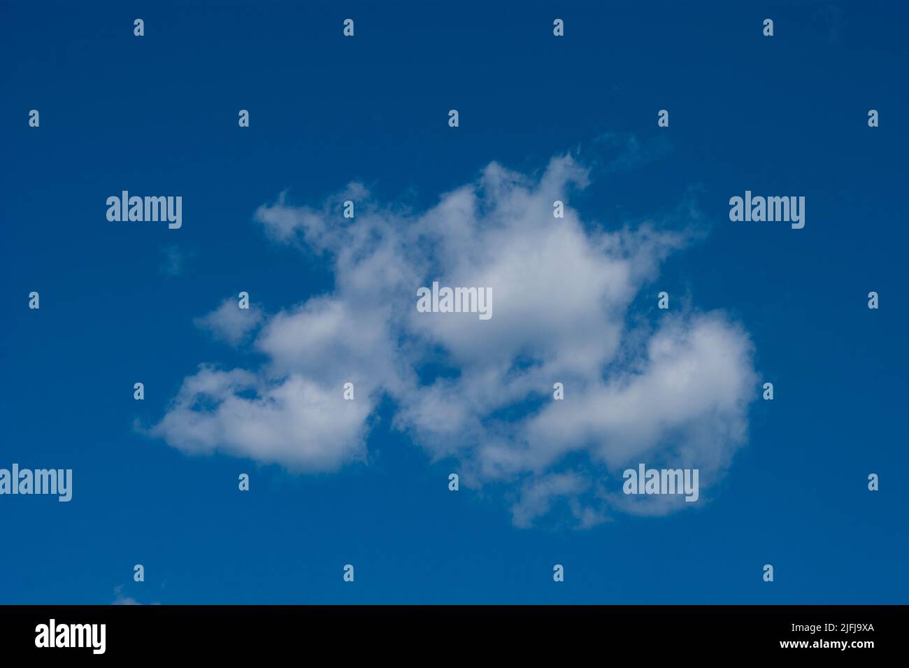 The horizontal photo is a blue sky with white fluffy clouds. Background, screensaver. Summer. Cloudy. Sunshine - Stock Image