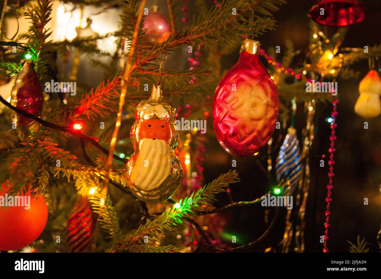 The holiday is a new year or Christmas, in the photo a live fir tree is decorated with toys, tinsel and beads. Retro. - Stock Image