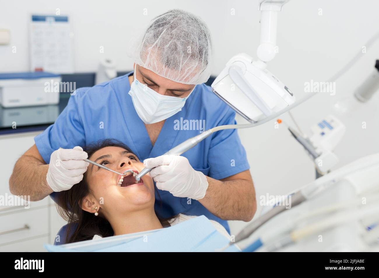 Male dentist drilling tooth to female patient Stock Photo Alamy