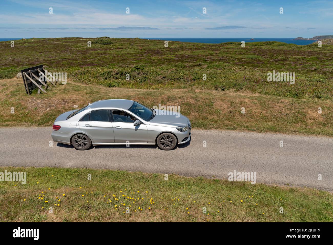 Cornwall, England, UK. 2022. A silver coloured car driving in the  Cornish coastal countryside close to Lands End  on the highway, UK Stock Photo