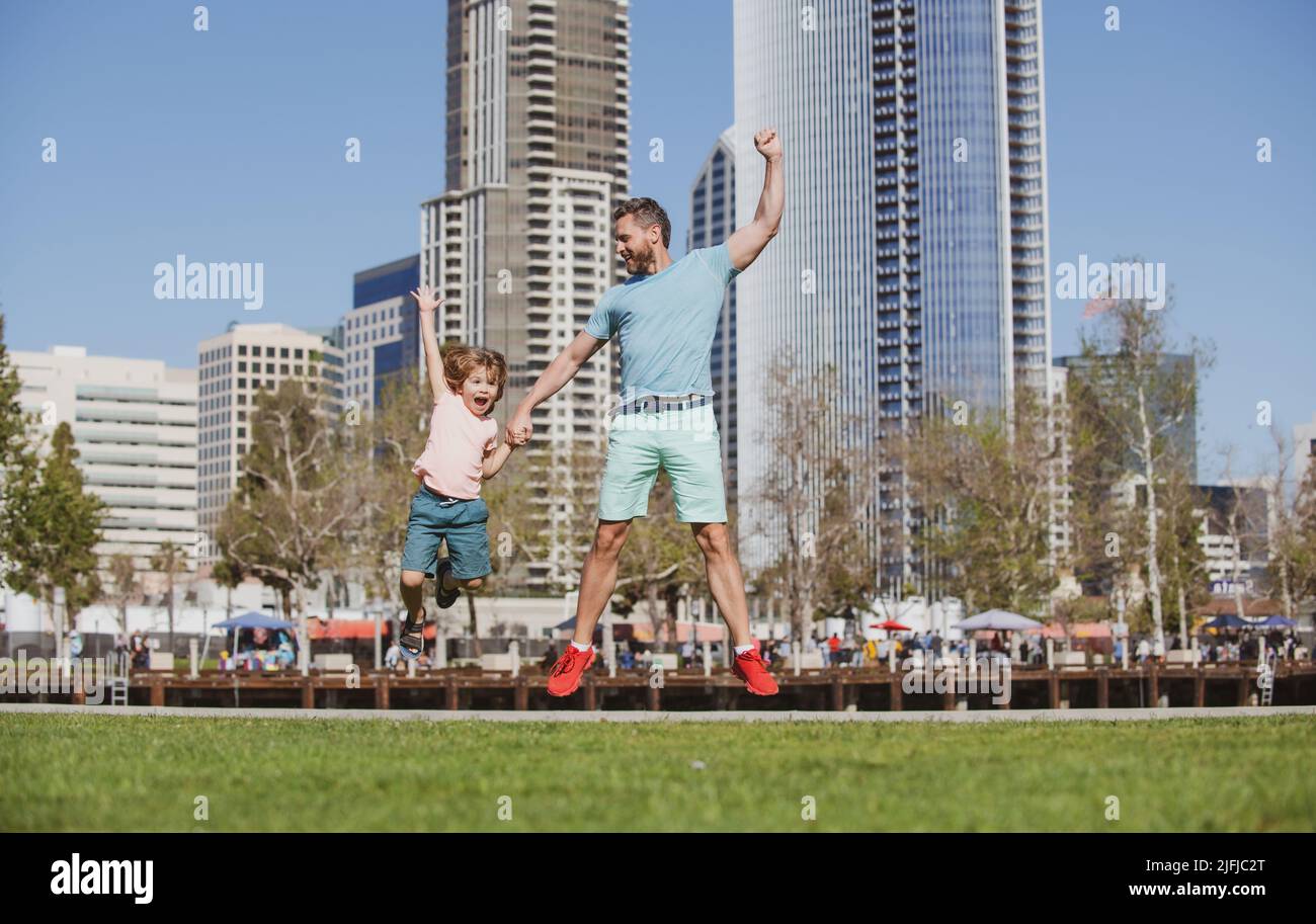 Father and son jumping in city. Dad and child at american city street ...