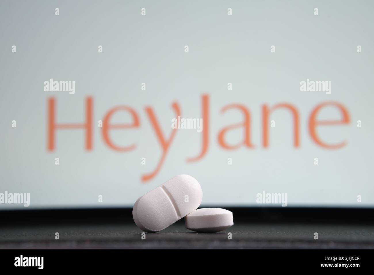 White pills and Hey Jane company logo on a blurred background. Concept for online telehealth abortion platform. Stafford, United Kingdom, July 3, 2022 Stock Photo