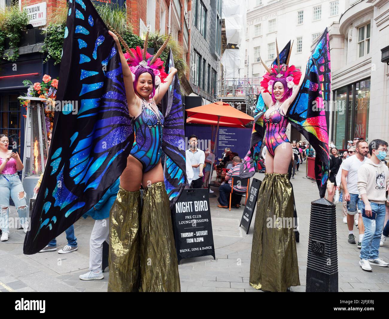 Ladies in colourful costumes outside the Coqbull Soho resaurant in Denman Street during the Pride in London celebrations in 2022 Stock Photo