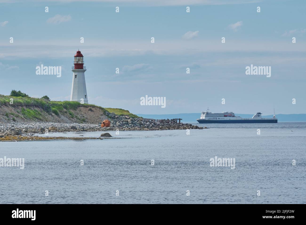 The Low Point Lighthouse is located near New Victoria Nova Scotia and marks the eastern entrance to Sydney Harbour.  Still in operation today it is on Stock Photo