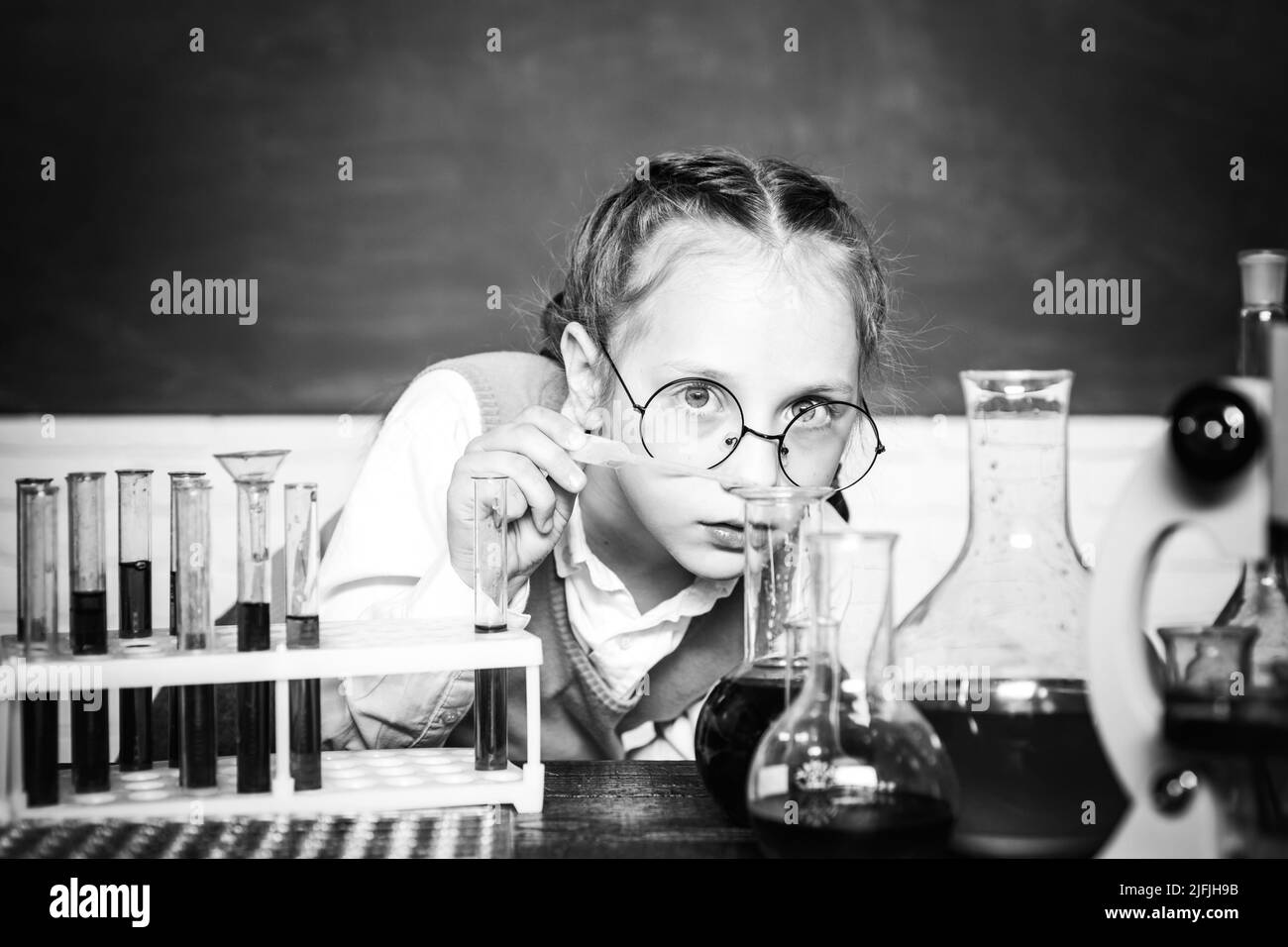 Lab microscope and testing tubes. My chemistry experiment. Back to school and happy time. Cheerful smiling little boy having fun against blue wall Stock Photo