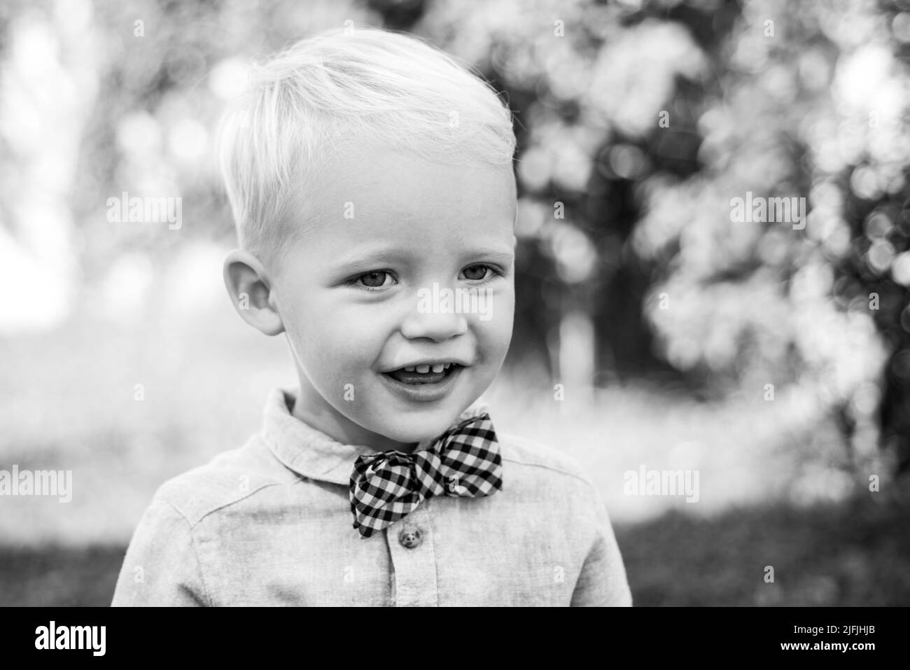 Has happy. International childrens day. Adorable baby having fun. Boy in suit and bowtie. Portrait of happy smiling child boy on nature background Stock Photo