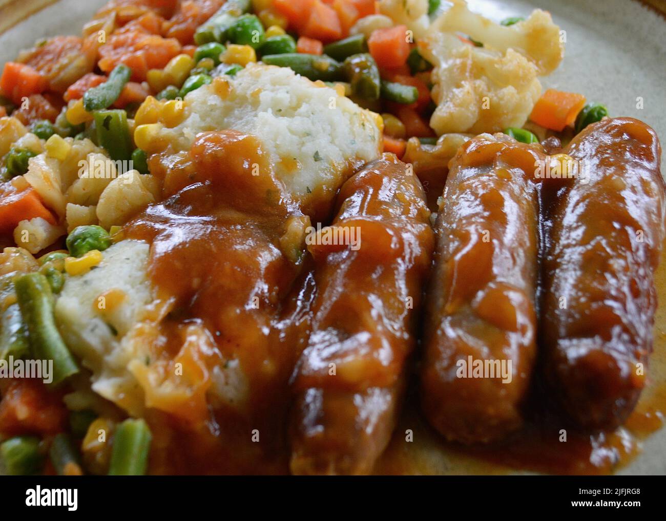 Sausages with onion gravy and vegetables Stock Photo Alamy