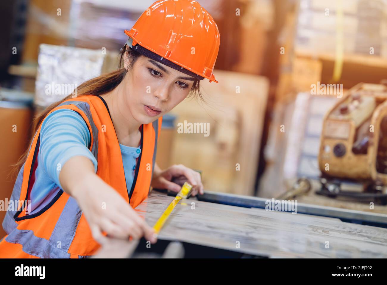 Young teen Asian woman engineer worker working in heavy industry with intension fine detail at work. Stock Photo