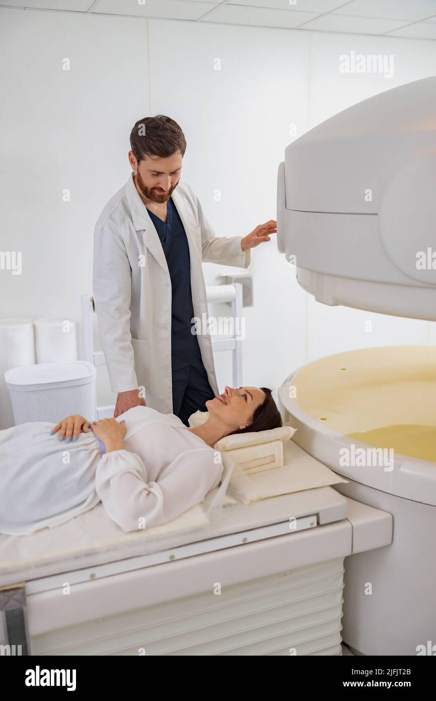 Radiologist controls MRI or CT or PET Scan with female patient