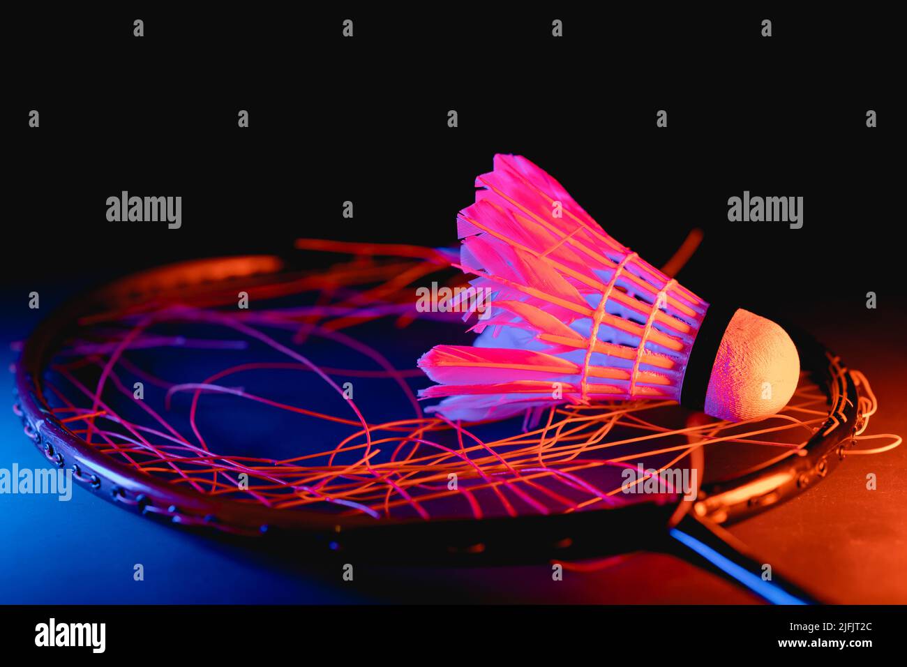badminton shuttlecock with badminton racket breaking strings on court