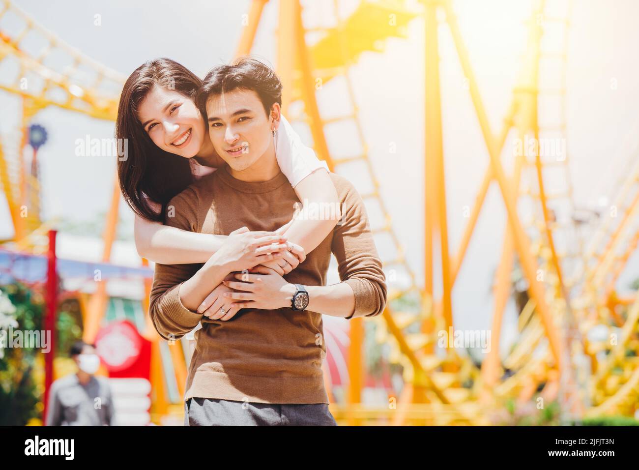 Portrait Asian couple lover happy outdoors at amusement park holiday activity together with copy space. Stock Photo