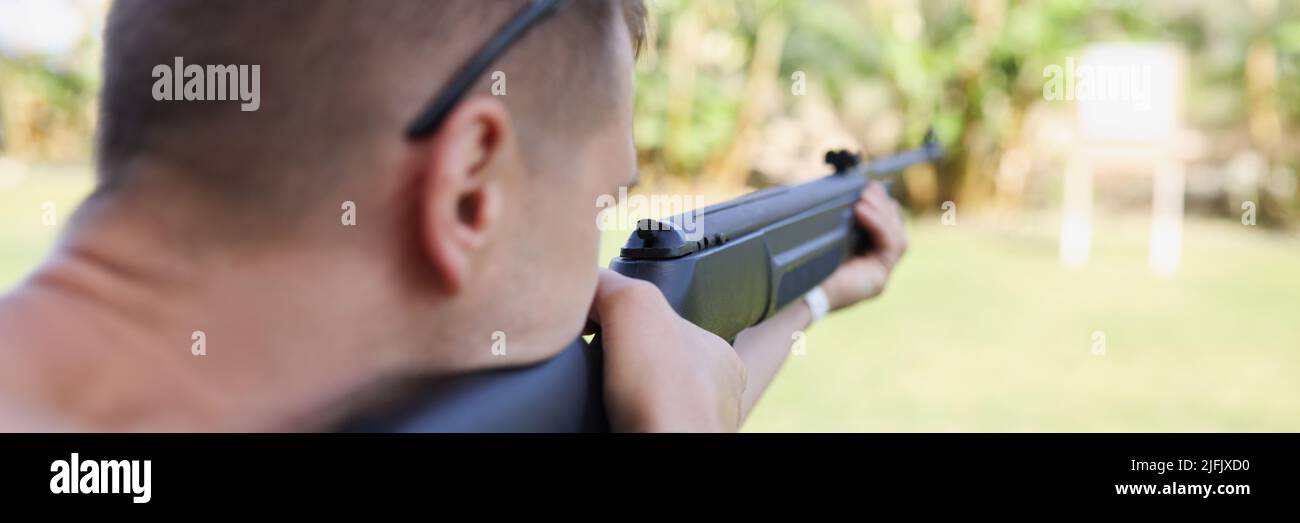 A man is aiming at a target with a gun, close-up Stock Photo