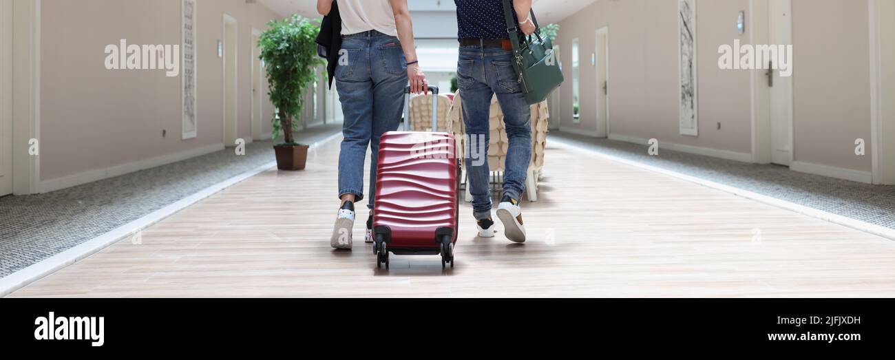 Couple walking with luggage along the hotel corridor Stock Photo
