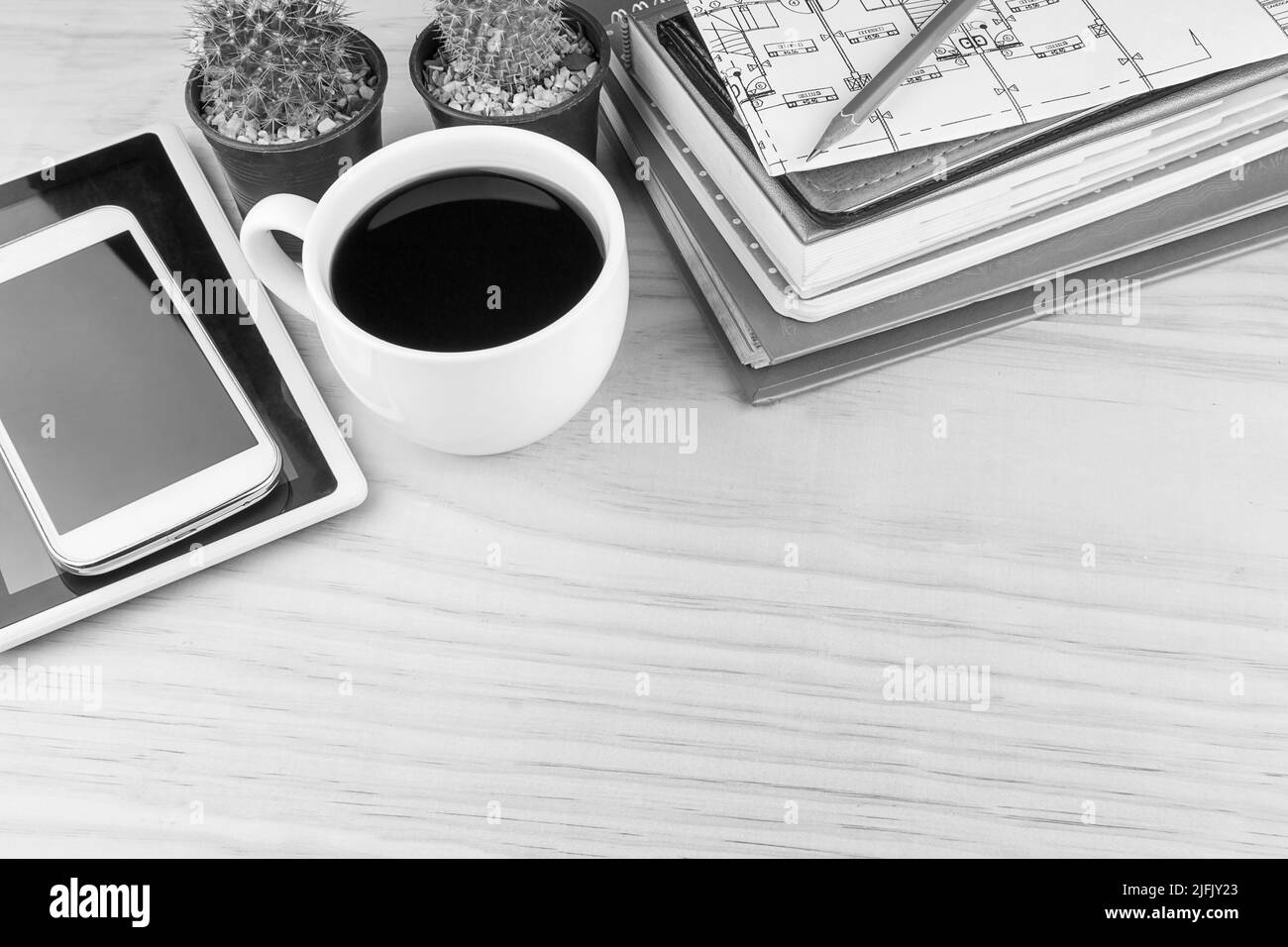 Office desk table with notebooks,glasses, smart phone and a cactus with