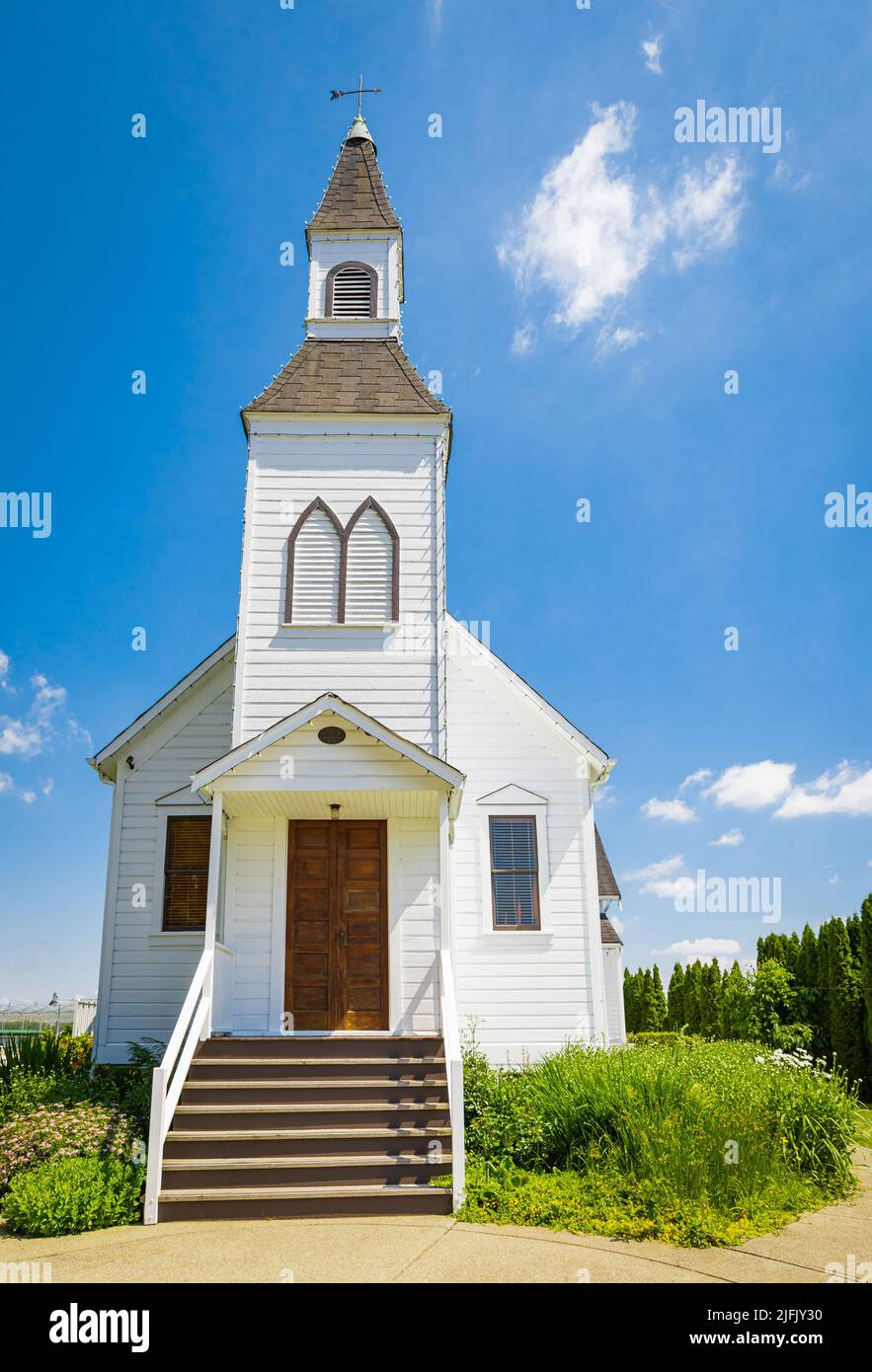 Exterior of a Little White Country Church on a Sunny Day and blue sky at the background. Beautiful traditional church in rural Canada-June 30,2022-Lan Stock Photo