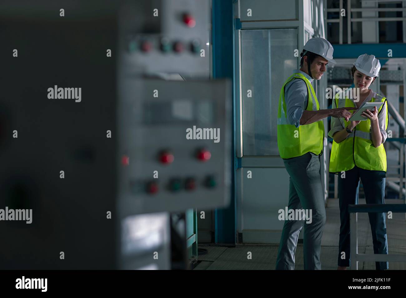 Mid adult man with his colleague working on digital tablet in the factory Stock Photo
