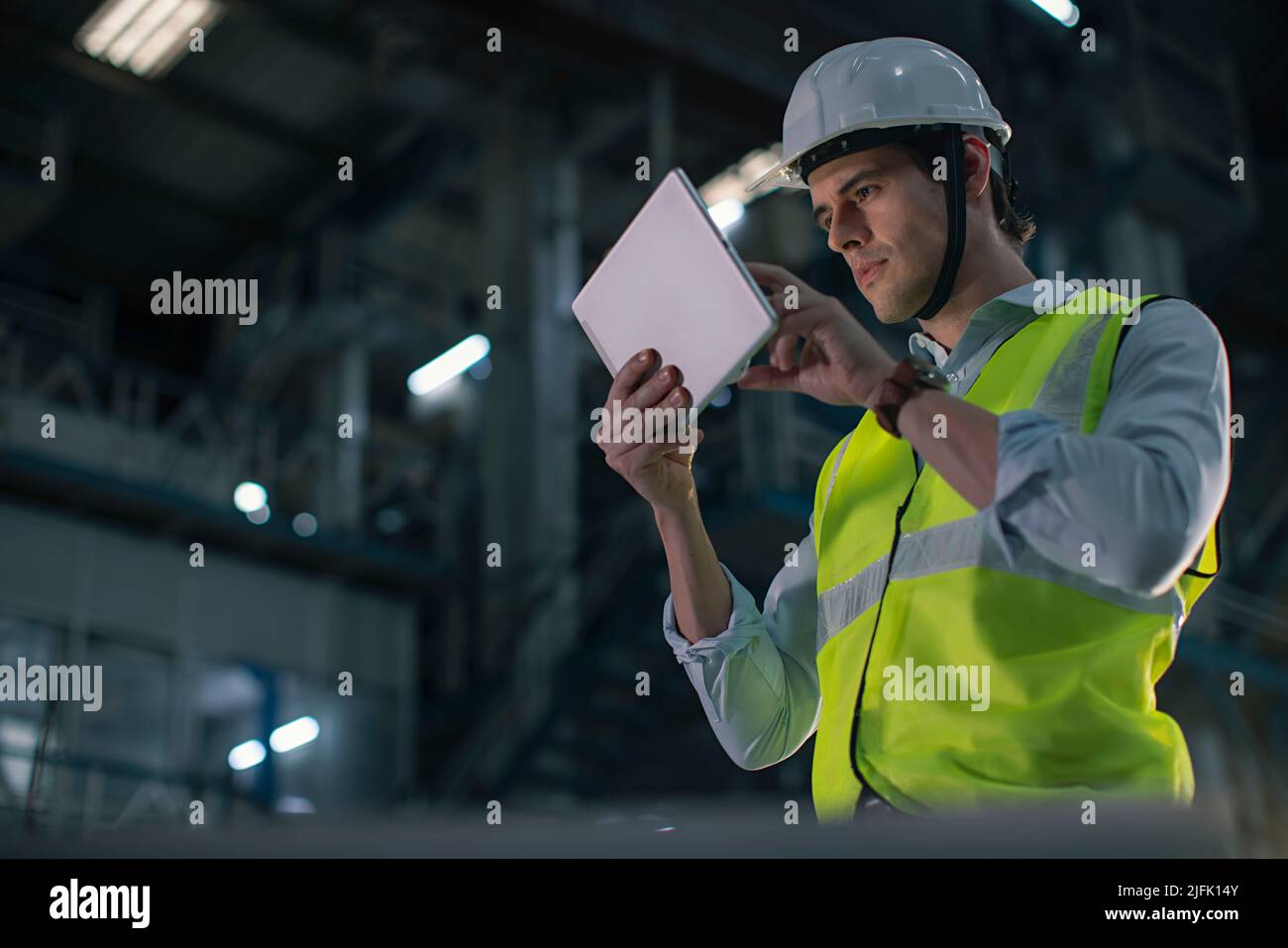 Mid adult man working on the digital tablet in the factory Stock Photo