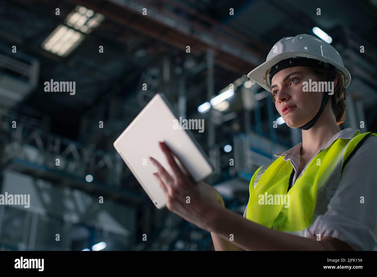 Young woman working on the digital tablet in the factory Stock Photo